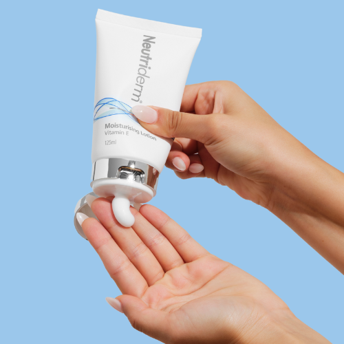 125ml Neutriderm Moisturising Lotion tube being squeezed, showing product texture in a lifestyle setting.